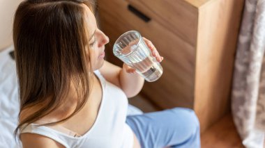 Hamile kadın suyu içiyor. Genç hamile anne su içiyor. Bebek bekleyen hamile bir kadın. Bir bardak su. Gebelik kavramı, doğum