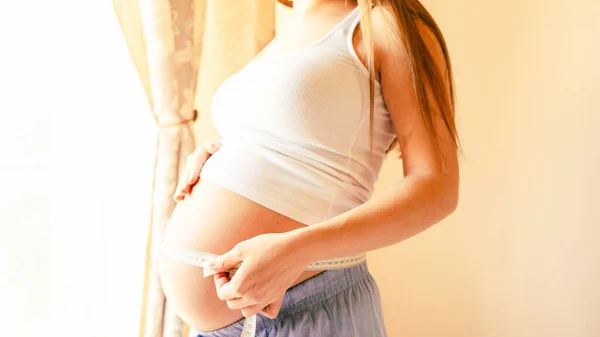 腹サイズの妊婦測定 腹を測定するテープで幸せな若い妊婦 母親としての概念 — ストック写真