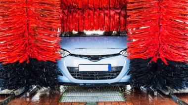 Otomatik oto yıkama, otomatik oto fırça yıkama istasyonunda temiz mavi araba. Otomatik oto yıkama servisi