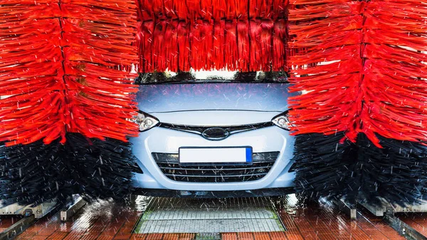 Otomatik oto yıkama, otomatik oto fırça yıkama istasyonunda temiz mavi araba. Otomatik oto yıkama servisi