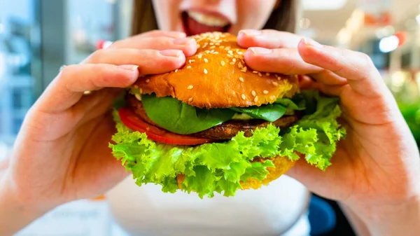 Vegan burger healthy vegetarian hamburger. Salad, avocado, vegetable on veggie sandwich eating cute woman. Vegetarian hamburger healthy diet food