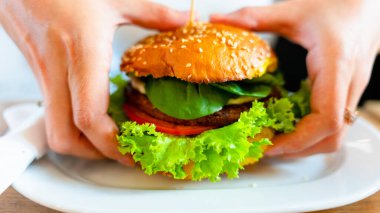 Vejetaryen burger sağlıklı vejetaryen hamburger. Salata, avokado, sebzeli sandviç ve tatlı bir kadın. Vejetaryen hamburgeri sağlıklı diyet yemekleri