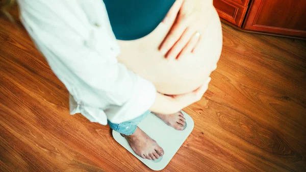 妊娠期体重增加 快乐的孕妇站在举重秤上 概念孕产 — 图库照片
