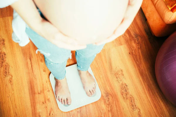 怀孕体重增加的女人 快乐的孕妇站在举重秤上治疗 母性概念 — 图库照片
