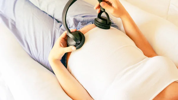 Pregnant music woman listen. Mother belly listen headphones sound. Pregnancy woman listening to music. Concept maternity, pregnancy, childbirth