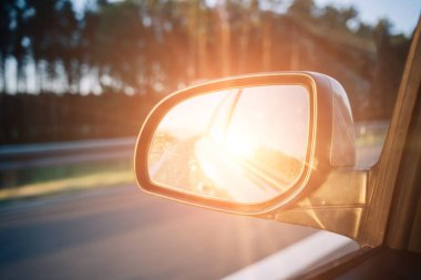 Car sunset road mirror. Summer sun, highway car road reflection in mirror. Vacation trip concept
