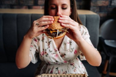 Hamburger girl eat. Pretty Young Happy Woman Eating Tasty Burger. Junk Food Concept