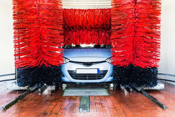 Car washing automatic carwash. Brush washer clean blue auto car on automatic car wash station. Carwash cleaning service