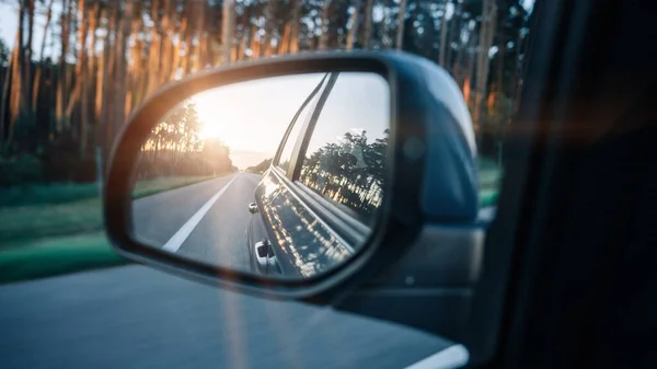 Road trip car mirror. Sun, highway car road reflection in mirror. Summer holidays trip concept