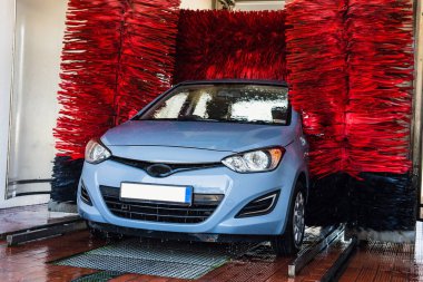 Car washing automatic carwash. Brush washer clean blue auto car on automatic car wash station. Carwash cleaning service