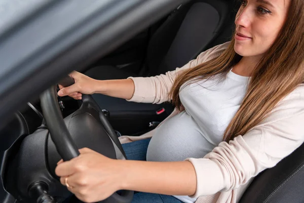 Pregnancy woman driving car. Young smiling pregnant woman driving car. Safety pregnancy young mother drive concept