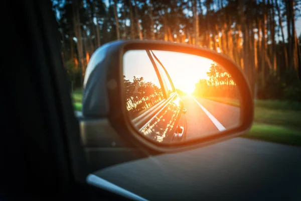Trip sunset car mirror. Sun, highway car road reflection in mirror. Summer holidays trip concept