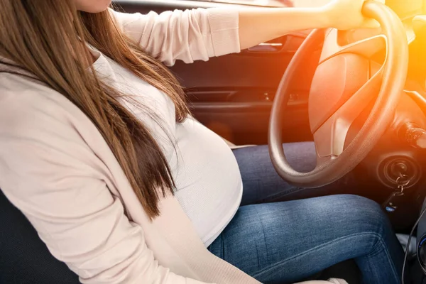 Woman driving car. Beautiful smiling pregnant woman driving car. Safety pregnancy young mother drive concept