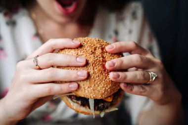 Burger eating woman. Pretty Young Happy Girl Eat Tasty Hamburger. Junk Food Concept