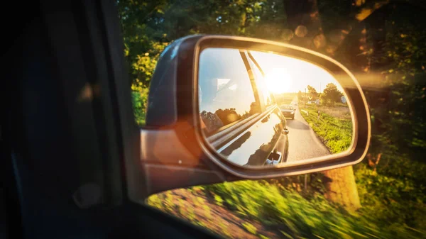 Road sunset car mirror. Summer sun, highway car road reflection in mirror. Vacation trip concept