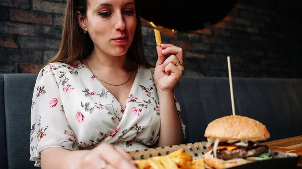 Woman burger eating. Hungry Girl Biting Hamburger. Fast food, people and unhealthy eating concept