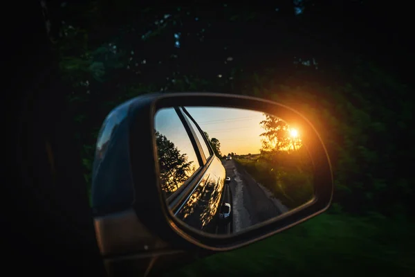 Trip sunset car mirror. Sun, highway car road reflection in mirror. Summer holidays trip concept