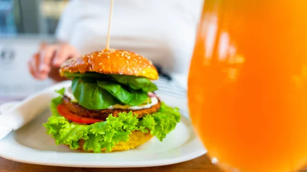 Vegetarian hamburger healthy vegan burger. Cute cheerful girl eating veggie sandwich with salad, avocado, vegetable. Vegan burger healthy diet food