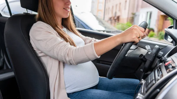 Pregnancy woman driving car. Young smiling pregnant woman driving car. Safety pregnancy young mother drive concept