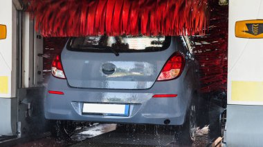 Car washing automatic carwash. Brush washer clean blue auto car on automatic car wash station. Carwash cleaning service