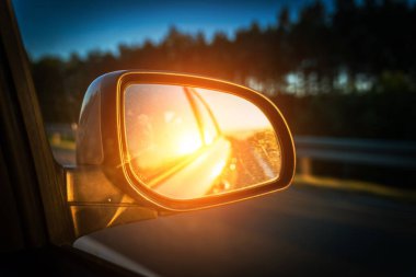 Road sunset car mirror. Summer sun, highway car road reflection in mirror. Vacation trip concept