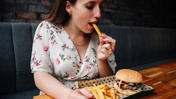 Fast food burger eat. Pretty Young Happy Woman Eating Tasty Hamburger. Junk Food Concept