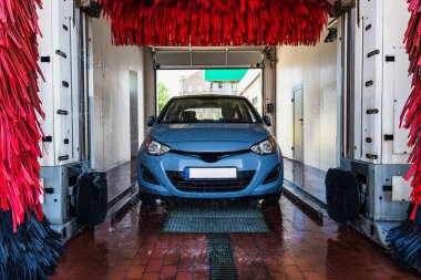 Car wash background automatic carwash. Brush washer clean blue auto car on automatic carwash station. Automated car washing service
