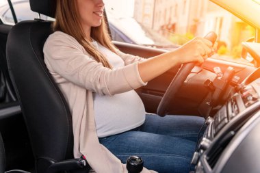 Pregnancy driving car. Young beautiful pregnant woman driving car. Safety pregnancy, mother health care concept