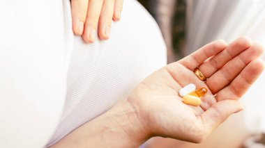 Hamilelik ilacı vitamin hapı. Elinde vitamin hapı tutan mutlu hamile kadın. Diyet beslenme. Sağlıklı beslenme, yaşam tarzı