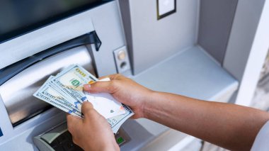ATM kartı, nakit. Amerikan banknotlarını elinde tutuyor. Kadın, 100 dolar çekmiş. Banka kredi kartı para geçmişi