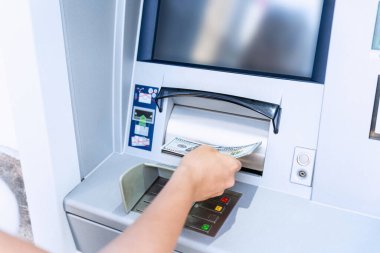 ATM kartı, nakit. Amerikan banknotlarını elinde tutuyor. Kadın, 100 dolar çekmiş. Banka kredi kartı para geçmişi