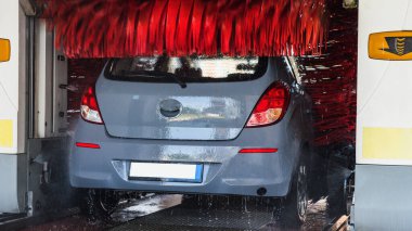 Car washing automatic carwash. Brush washer clean blue auto car on automatic car wash station. Carwash cleaning service
