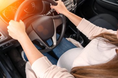 Woman driving car. Beautiful smiling pregnant woman driving car. Safety pregnancy young mother drive concept