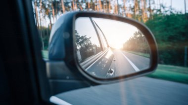 Road sunset car mirror. Summer sun, highway car road reflection in mirror. Vacation trip concept
