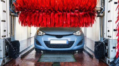 Car wash background automatic carwash. Brush washer clean blue auto car on automatic carwash station. Automated car washing service