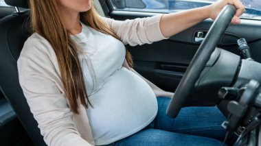 Pregnancy driving car. Young beautiful pregnant woman driving car. Safety pregnancy, mother health care concept