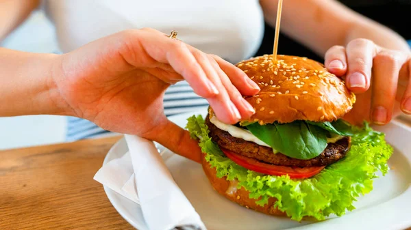 Veggie burger healthy vegan food. Salad, avocado, vegetable on vegetarian hamburger eating cute woman. Vegan sandwich healthy diet food