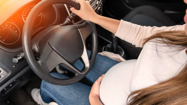 Pregnancy driving car. Young beautiful pregnant woman driving car. Safety pregnancy, mother health care concept