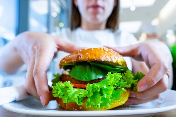 Vegan burger healthy vegetarian hamburger. Salad, avocado, vegetable on veggie sandwich eating cute woman. Vegetarian hamburger healthy diet food