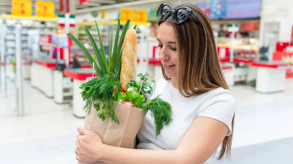 Woman shopping food grocery. Pregnant woman with healthy green vegetables, fresh tomato in market food bag on grocery supermarket background. Healthy food background