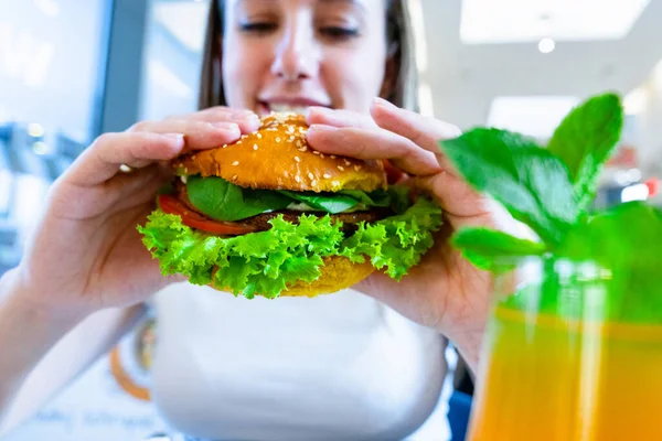 Vegan sandwich healthy vegetarian burger. Cute cheerful girl eating veggie hamburger with salad, avocado, vegetable. Vegetarian diet food concept