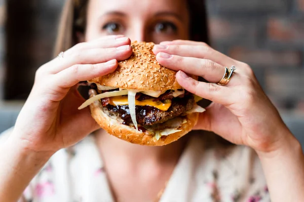 Fast food burger eat. Pretty Young Happy Woman Eating Tasty Hamburger. Junk Food Concept