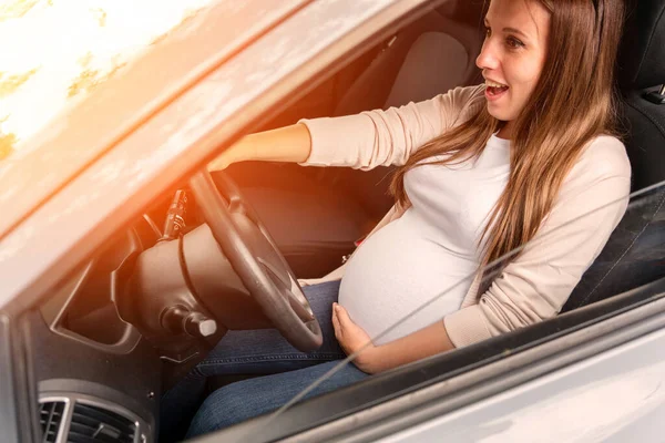 Pregnancy woman driving car. Young smiling pregnant woman driving car. Safety pregnancy young mother drive concept