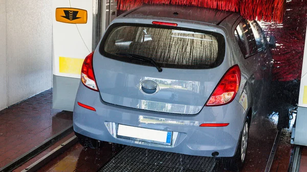 Automatic car wash. Auto brush washer clean blue car on automatic carwash station. Automatic car wash cleaning service