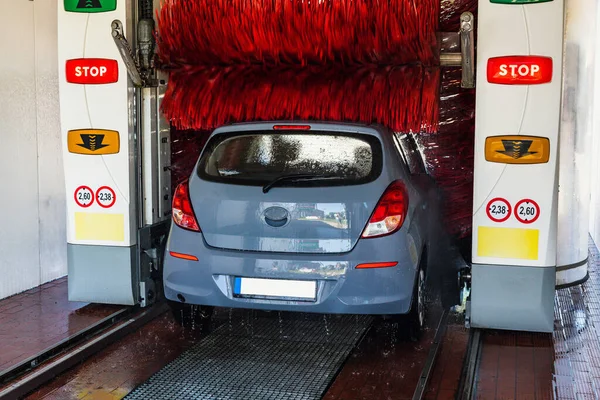 Auto car wash. Auto brush washer clean blue car on automatic carwash station. Automatic car wash background