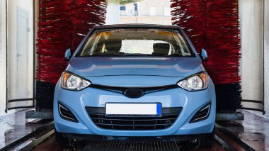 Auto car wash. Auto brush washer clean blue car on automatic carwash station. Automatic car wash background