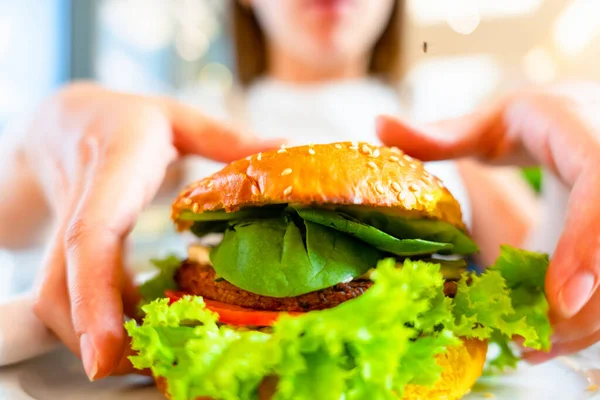 Vejetaryen burger sağlıklı vejetaryen hamburger. Salata, avokado, sebzeli sandviç ve tatlı bir kadın. Vejetaryen hamburgeri sağlıklı diyet yemekleri