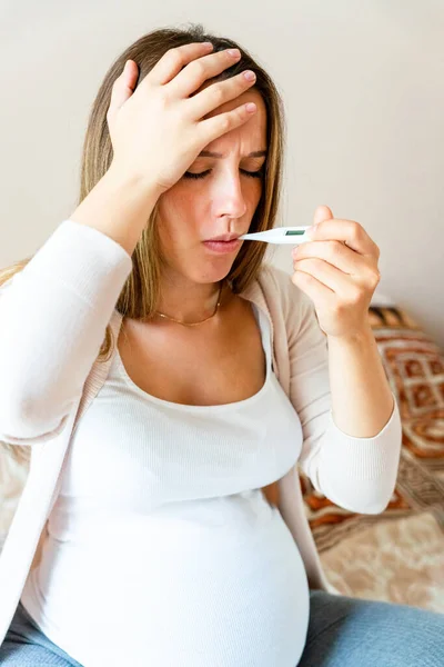 Pregnant sick fever thermometer. Pregnancy woman holding thermometer, check fever flu temperature. Pregnant girl sick. Pregnancy, medicine health care concept