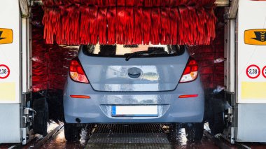 Car wash background automatic carwash. Brush washer clean blue auto car on automatic carwash station. Automated car washing service