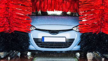 Auto car wash. Auto brush washer clean blue car on automatic carwash station. Automatic car wash background